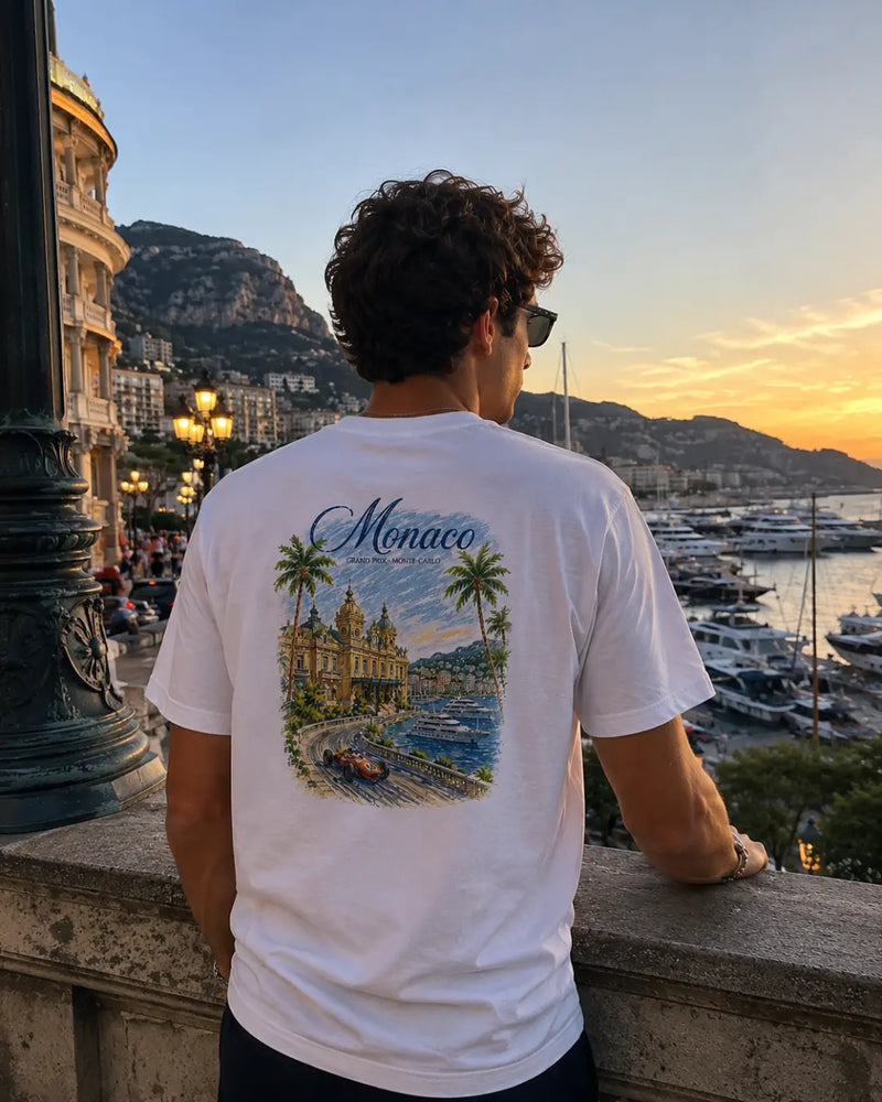 Ragazzo di spalle con t-shirt bianca Monaco Grand Prix Watercolor ChicGallery al porto di Monte-Carlo al tramonto